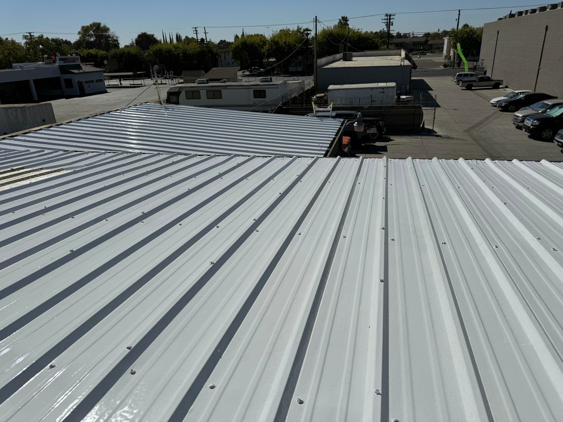 Standing on the coated metal roof, white panels running to the edge