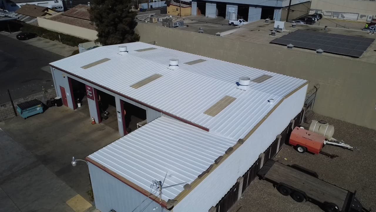 Aerial of the commercial shop with its metal roof coated white