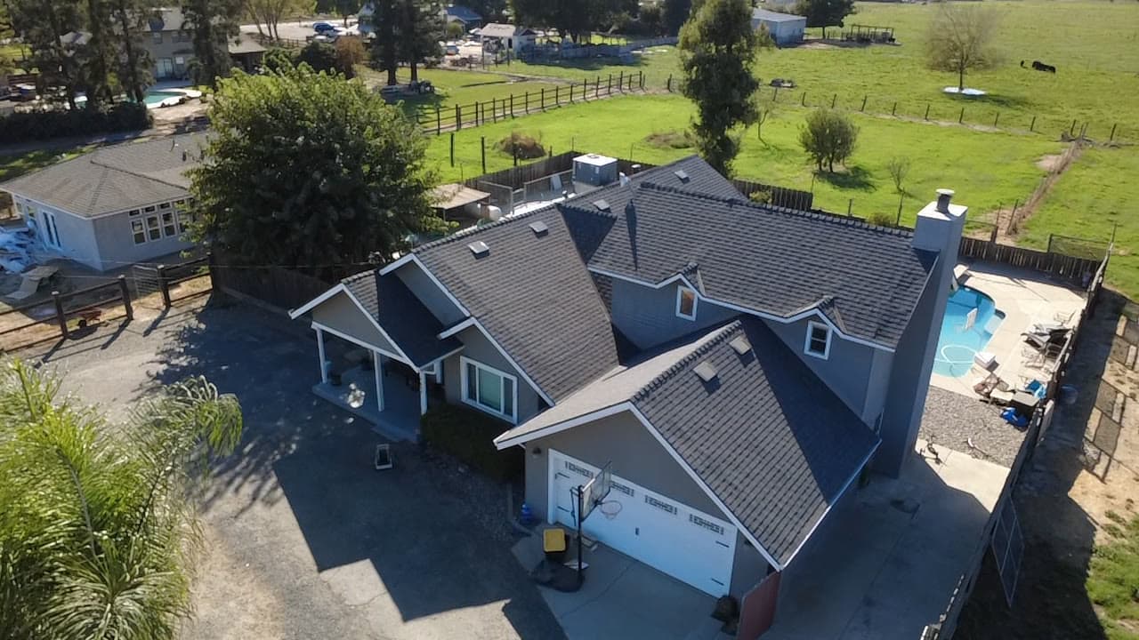 Finished shingle roof from the corner, open fields behind