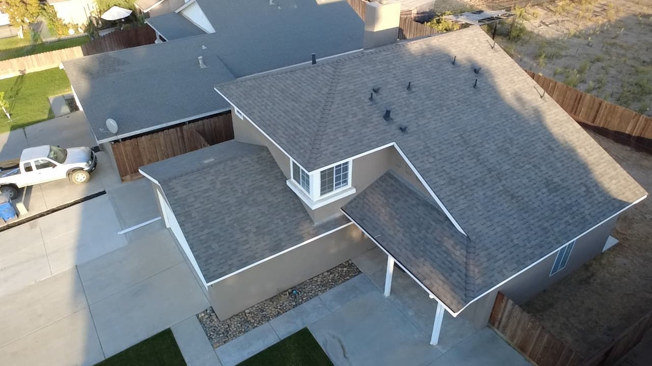 Finished two-story shingle roof at golden hour, gable end