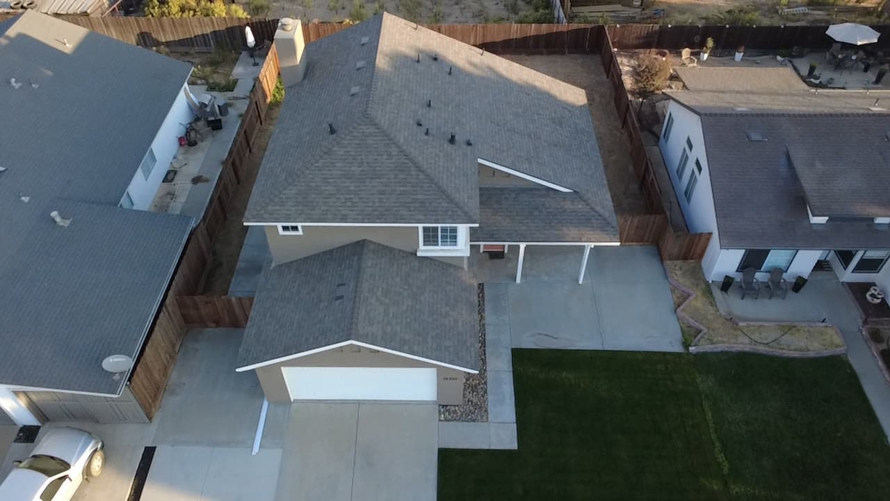 Finished two-story shingle roof at golden hour, along the ridge