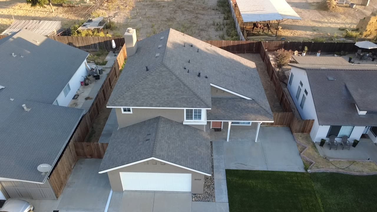 Finished two-story shingle roof at golden hour, from the street side