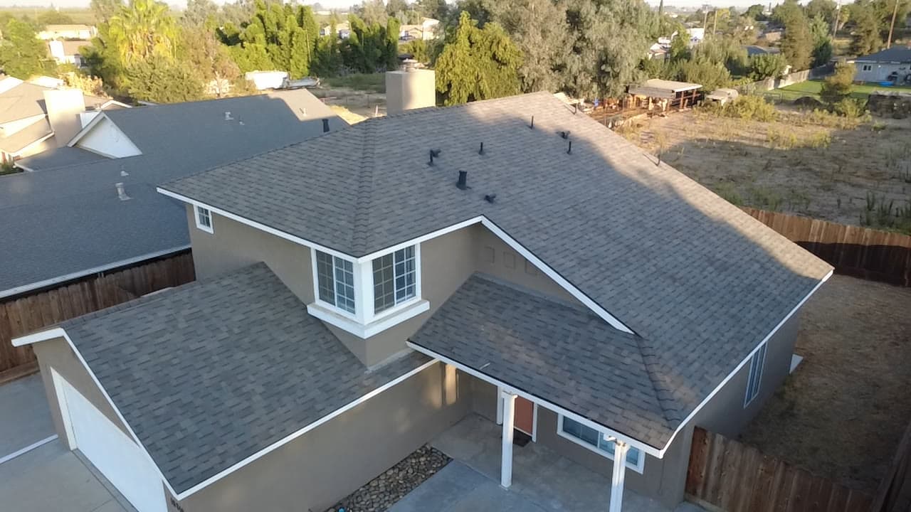 Finished two-story shingle roof at golden hour, three-quarter view